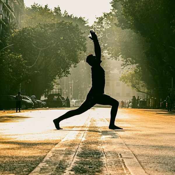 Person stretching outdoors during sunrise, showing flexibility and peace.